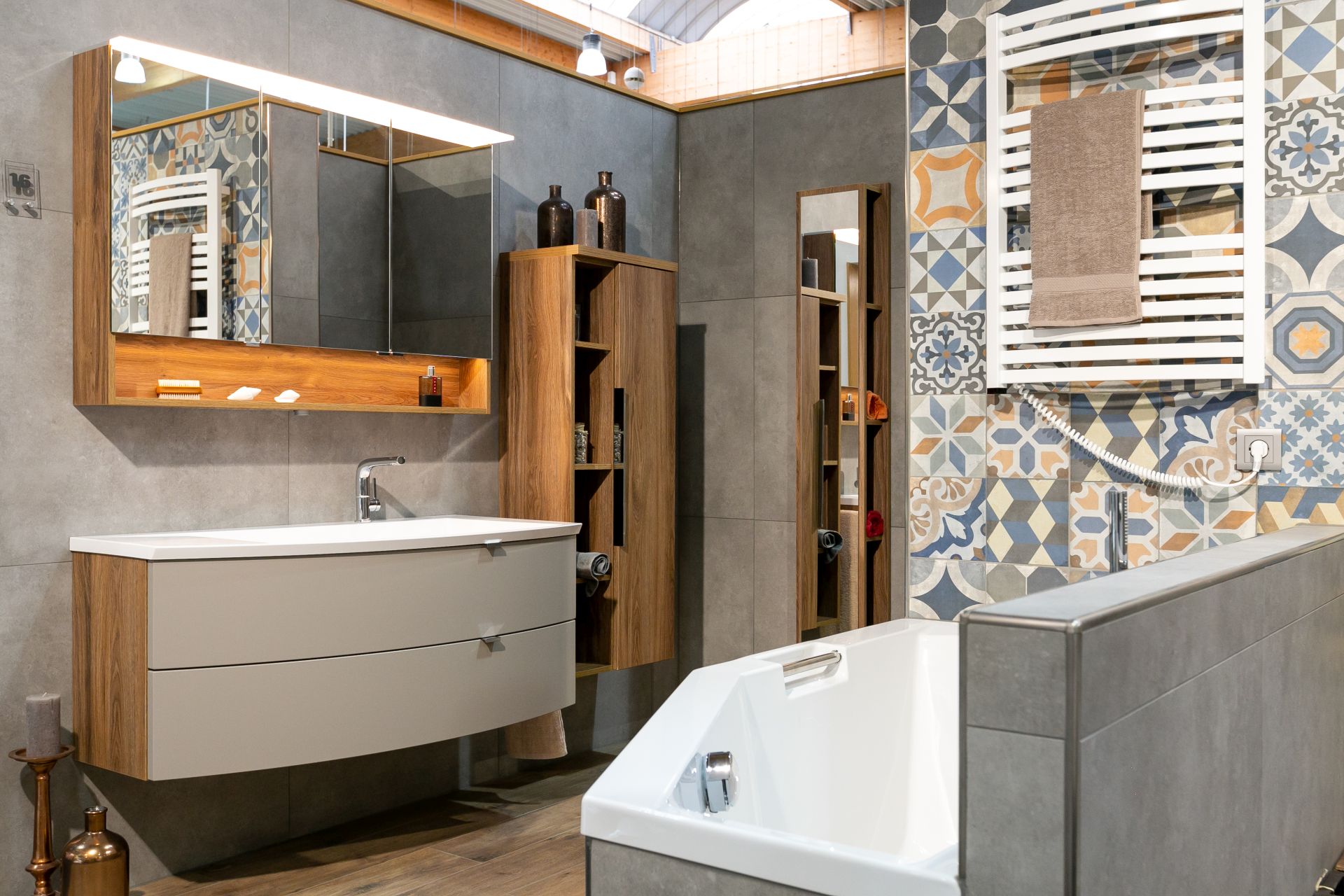 Modernes Badezimmer mit verschiedenen Fliesen an Wänden und Boden.